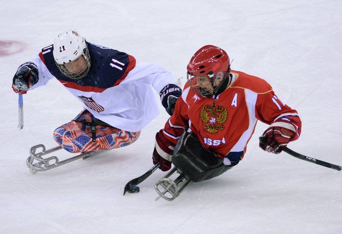 Борьба за шайбу Вадима Селюкина (справа) и игрока сборной США Тайлера Кэррона в финале Паралимпиады.